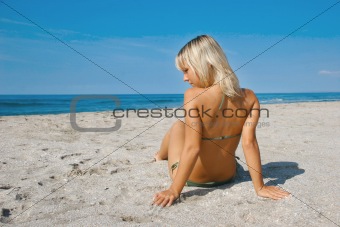young tanned girl on sandy beach