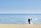 happy wedding couple standing on beach
