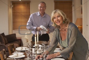 Couple Preparing Table For A Dinner Party
