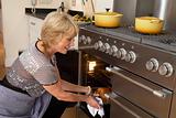 Woman Taking Food Out Of The Oven