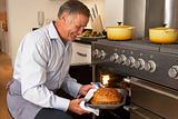 Man Taking Food Out Of The Oven