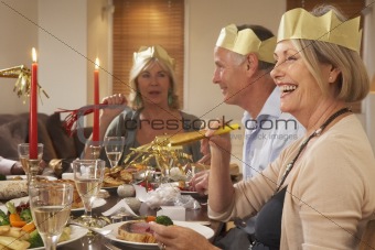 Friends Wearing Party Hats At A Dinner Party