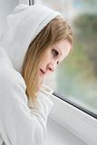 beautiful young girl is sad at the window