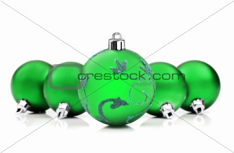 Bright green christmas baubles on white background with space for text