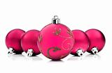 Bright pink christmas baubles on white background with space for text