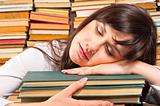 Overworked university student sleeping on her books