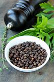 black pepper in a bowl and herbs thyme, basil