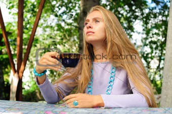 Girl pondering in the summer cafe
