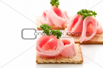 Crackers canapes with ham and parsley