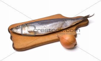 Herring with onion on kitchen board