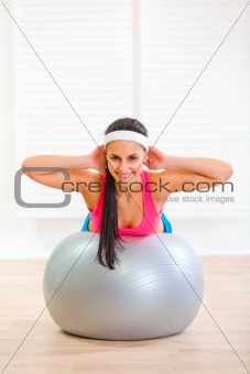 Happy fitness girl doing abdominal crunch on fitness ball