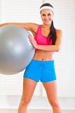 Smiling healthy girl holding fitness ball
