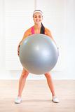 Happy healthy girl doing exercises with fitness ball
