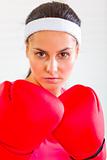 Portrait of concentrated fit girl in boxing gloves