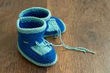 Knitted handmade baby's bootees on wood floor