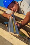 Builder carpenter measuring wood planck
