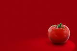 Red tomato on red background