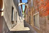 Old narrow street amont ancient houses in Avigliana, Italy.
