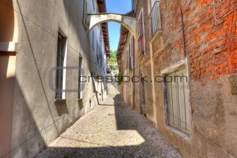 Old narrow street amont ancient houses in Avigliana, Italy.