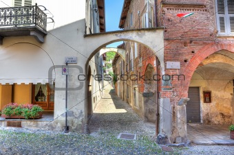 Old narrow street among ancient houses in Avigliana, Italy.