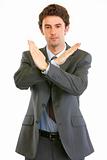 Confident businessman with crossed arms. Forbidden gesture
