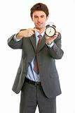 Modern businessman pointing on alarm clock
