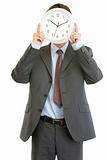 Modern businessman holding clock in front of face
