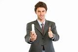 Modern businessman with fluorescent lamp showing thumbs up gesture. Environmental protection concept
