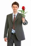 Smiling modern businessman with red rose in hand
