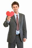 Smiling modern businessman with Valentin heart in hand
