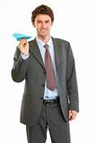 Smiling modern businessman with paper airplane
