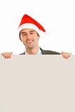 Smiling guy in Santa hat holding blank billboard
