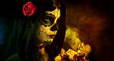 Artistic shot of sugar skull girl with dead roses 