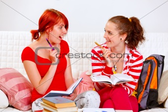 Two pretty girlfriends making homework
