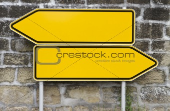 direction signs with wall in background