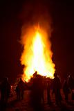 People Standing Around A Big Bonfire At Night