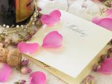 Wedding Invitation Next To Champagne Bottle Surrounded By Flower