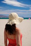 red woman with straw hat at beach