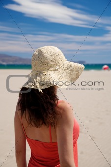 red woman with straw hat at beach