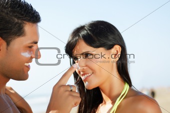 couple on the beach  putting on cream