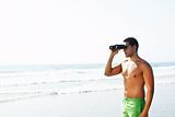 boy with binoculars  looking at the seashore