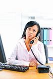 Concerned black businesswoman on phone at desk
