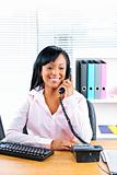 Smiling black businesswoman on phone at desk