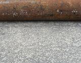 industrial rusty steel pipe laying on pavement