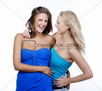 two young happy female friends standing laughing - isolated on white