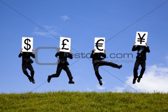 businessman jumping  and holding 4 different currency signs