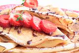 sweet pancakes with strawberries on red plate