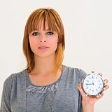 beautiful young woman holding alarm clock 