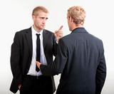 ywo you businessmen standing, discussing, arguing - isolated on light gray