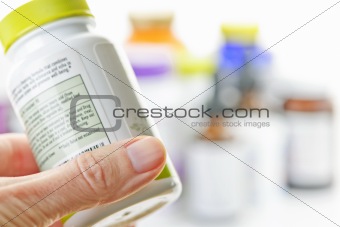 Hand holding medicine bottle